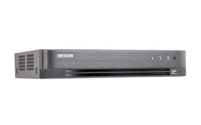 Front and side view of a Hikvision DVR unit with a brushed metal finish, featuring LED status indicators and a front-facing USB port for security footage backup.